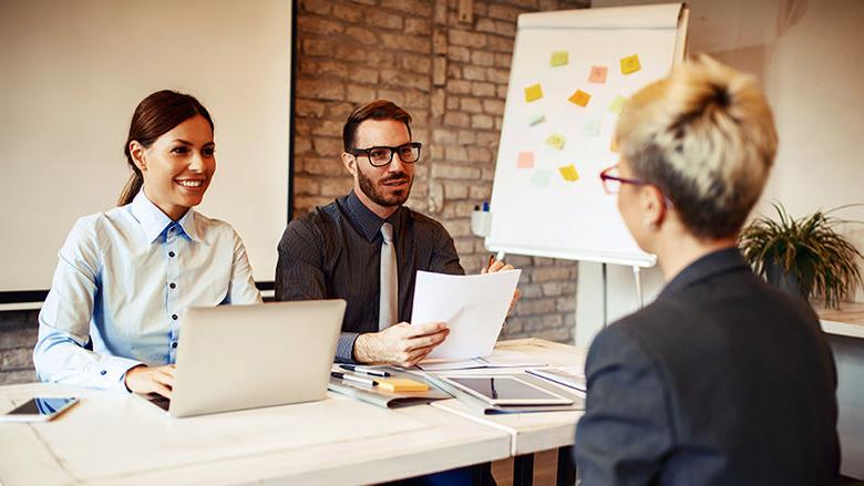 Stock photo of two young professionals interviewing a third